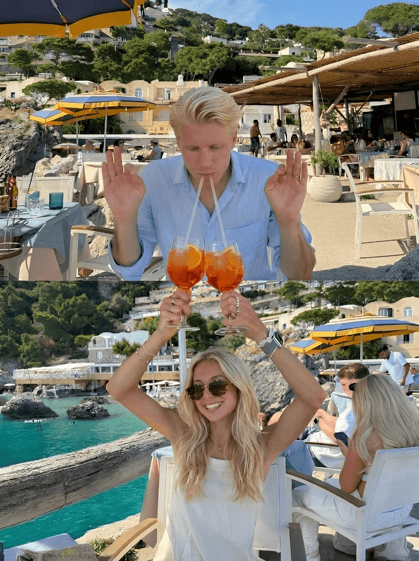 A couple stacked into one photo — a man reaching out of the frame above a woman raising Aperol spritzes